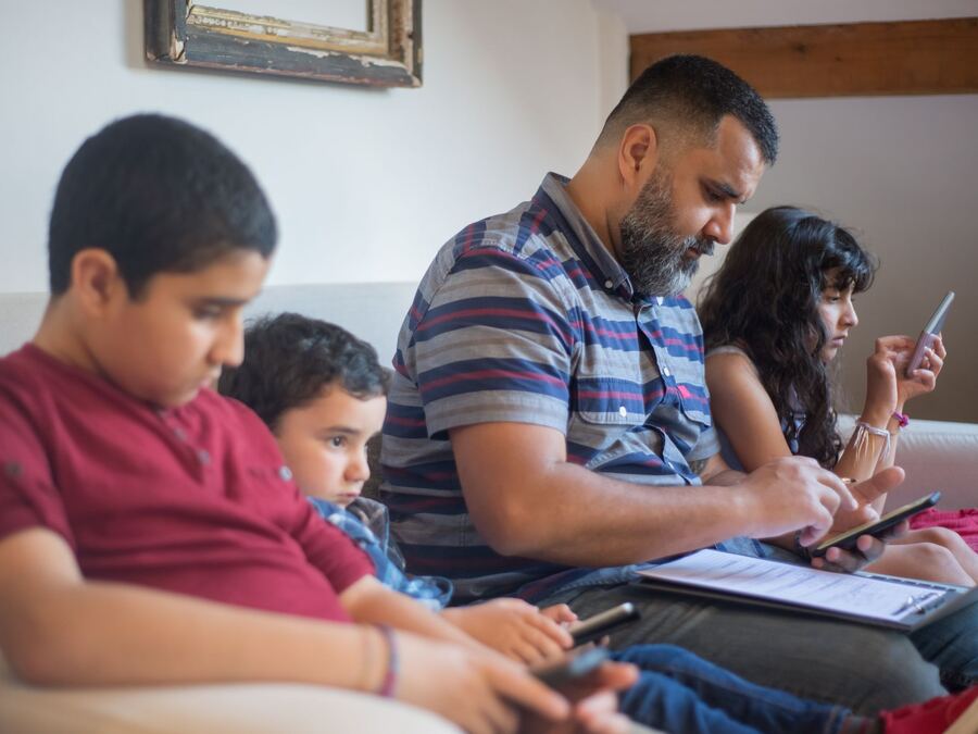 A parent checking their children's school updates on a phone at home